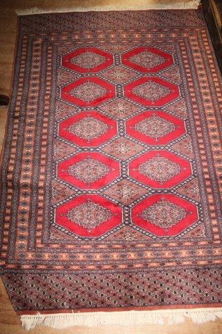 Bokhara red ground rug, woven with octagons(-)